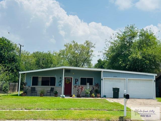 2226 E Austin Ave, Harlingen, TX 78550 - view of front of home featuring an attached garage, a front lawn, and driveway