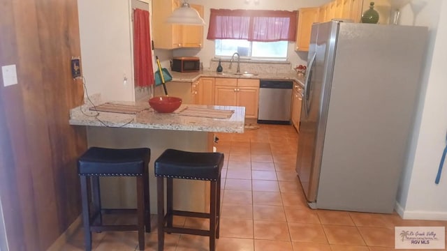 2226 E Austin Ave, Harlingen, TX 78550 - kitchen featuring stainless steel appliances, light tile patterned flooring, a peninsula, and a kitchen breakfast bar