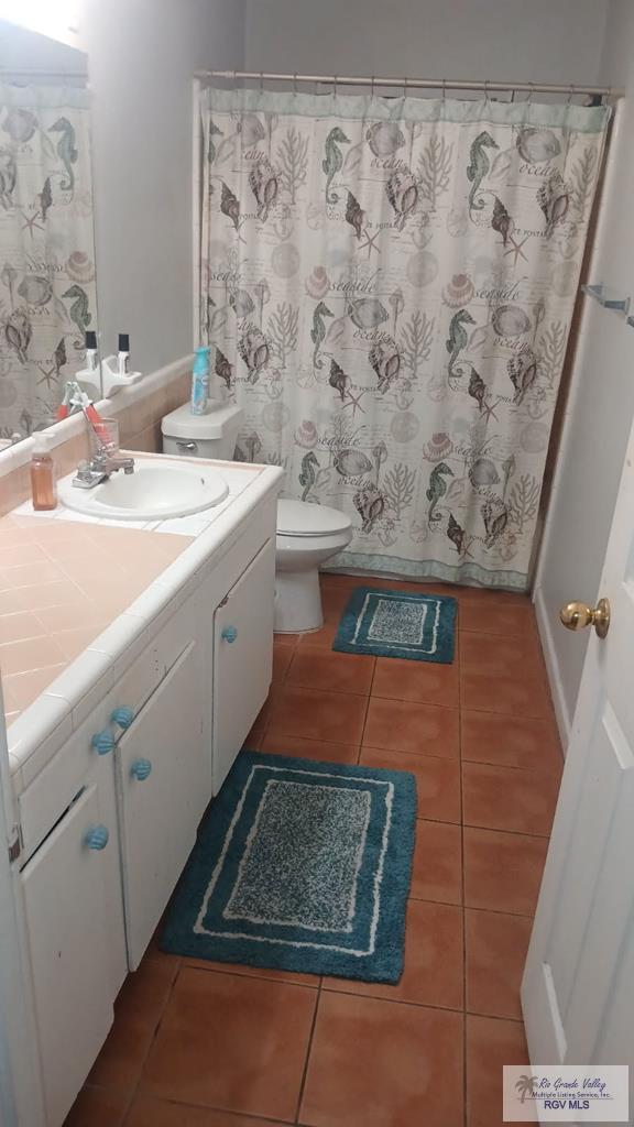 2226 E Austin Ave, Harlingen, TX 78550 - living area featuring tile patterned floors and baseboards