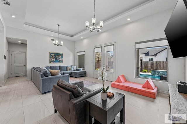 living area featuring visible vents, recessed lighting, baseboards, an inviting chandelier, and a raised ceiling