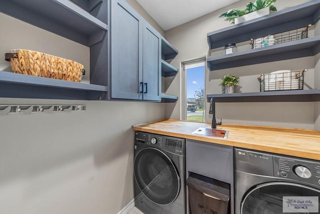 laundry area with cabinet space, independent washer and dryer, and a sink