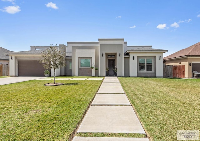 view of front facade with stucco siding, concrete driveway, a front yard, and fence