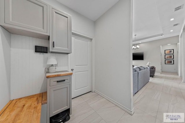 kitchen with gray cabinets, visible vents, and marble finish floor