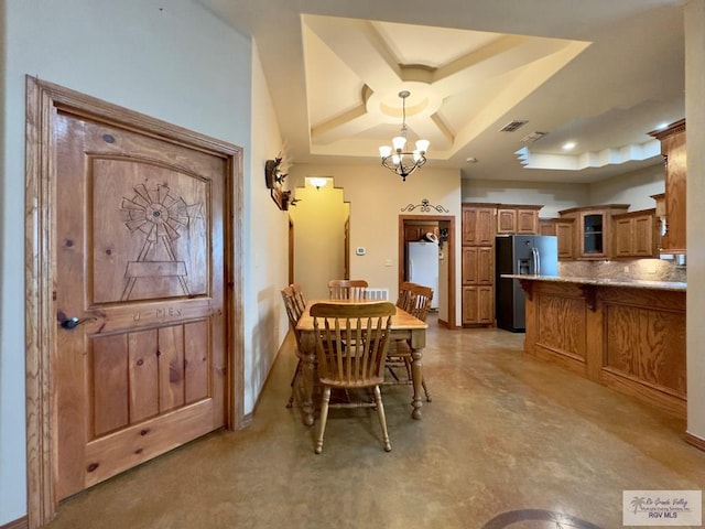 dining room featuring a raised ceiling and a chandelier