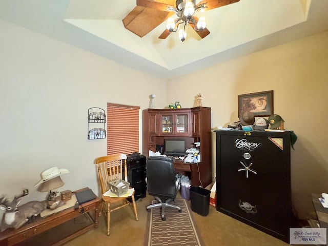 home office featuring carpet floors, a tray ceiling, and ceiling fan