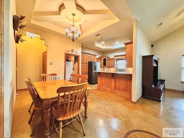 dining room featuring a chandelier and a raised ceiling