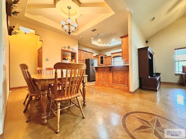 dining space featuring a notable chandelier and a raised ceiling
