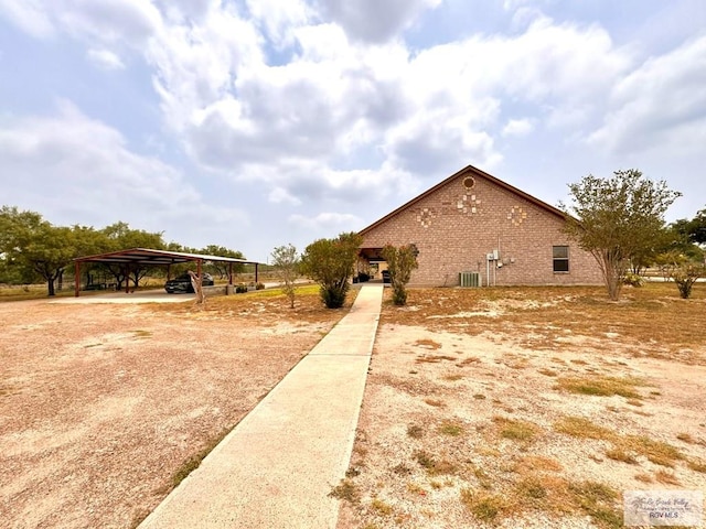 view of home's exterior with a carport and central AC unit