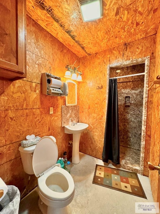 bathroom featuring sink, toilet, concrete floors, and a shower with shower curtain