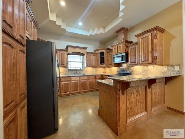 kitchen with kitchen peninsula, stainless steel appliances, a breakfast bar area, and tasteful backsplash