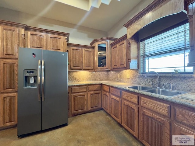 kitchen featuring tasteful backsplash, sink, and stainless steel refrigerator with ice dispenser