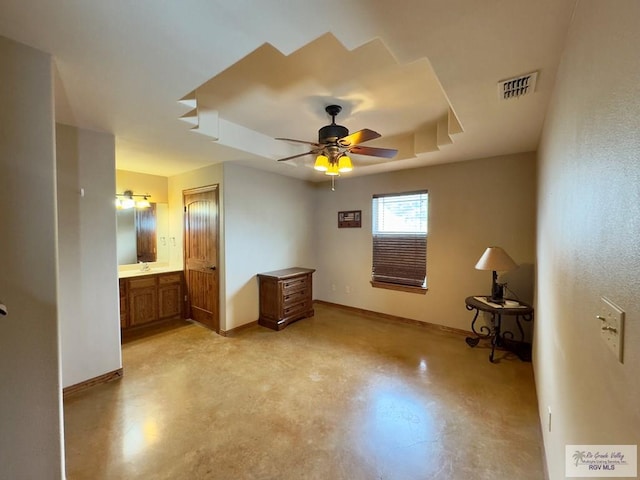unfurnished bedroom featuring connected bathroom, a tray ceiling, and ceiling fan