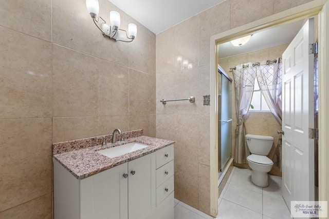 bathroom featuring vanity, tile patterned flooring, toilet, tile walls, and an enclosed shower