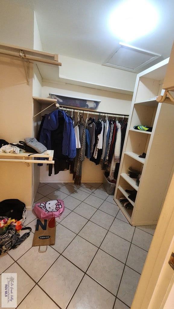 walk in closet with light tile patterned floors