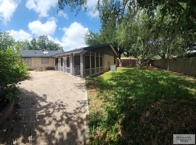 rear view of property featuring a patio and a lawn