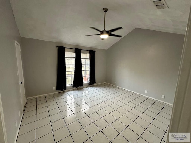 spare room featuring light tile patterned floors, visible vents, lofted ceiling, and a ceiling fan