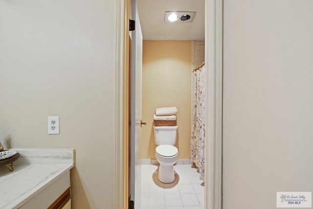 bathroom with tile patterned flooring, vanity, and toilet