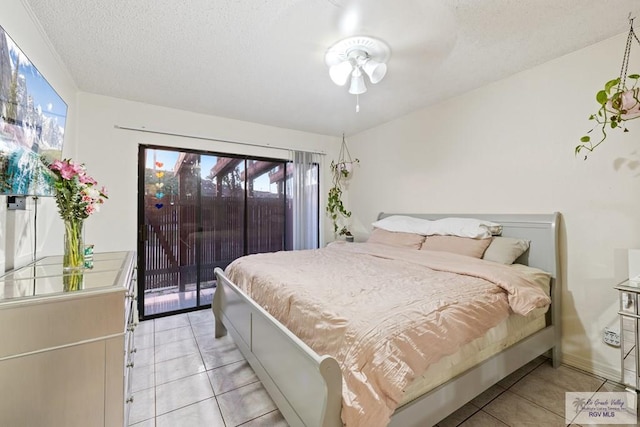 bedroom featuring ceiling fan, light tile patterned flooring, a textured ceiling, and access to outside