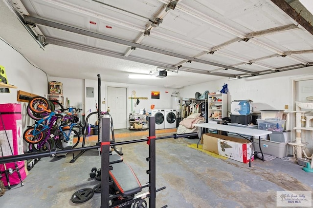 garage with a garage door opener and independent washer and dryer