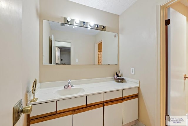 bathroom featuring a textured ceiling and vanity