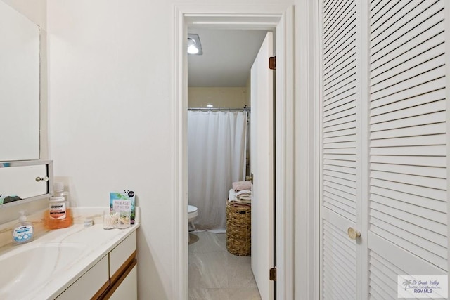 bathroom with tile patterned flooring, vanity, curtained shower, and toilet