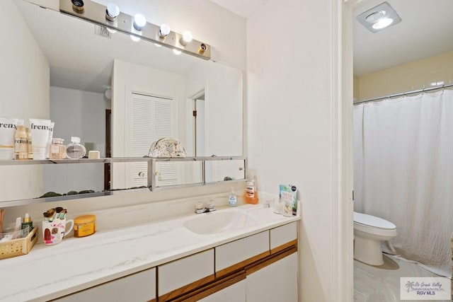 bathroom featuring tile patterned floors, vanity, and toilet