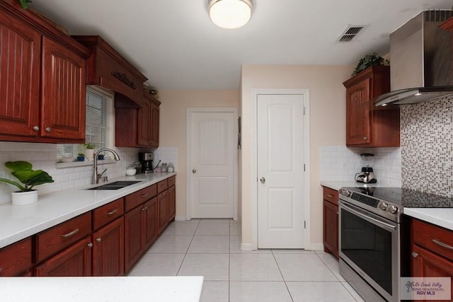 117 W 6th St, San Juan, TX 78589 - kitchen with stainless steel electric stove, a sink, wall chimney exhaust hood, and tasteful backsplash