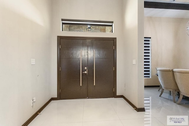 entrance foyer featuring baseboards and light tile patterned flooring