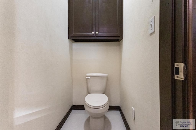 bathroom with toilet and baseboards