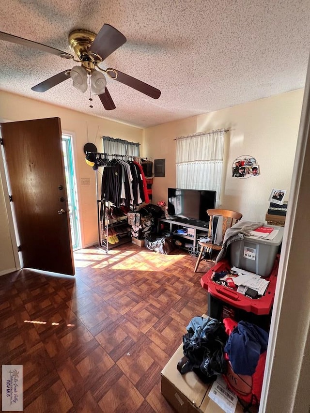 interior space with a textured ceiling and ceiling fan