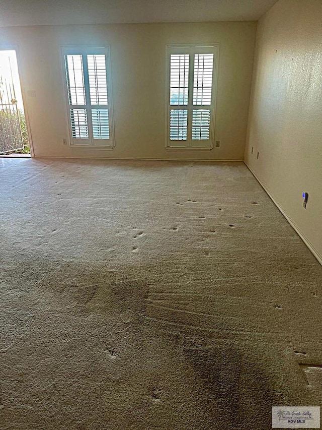 unfurnished room with a wealth of natural light and light colored carpet