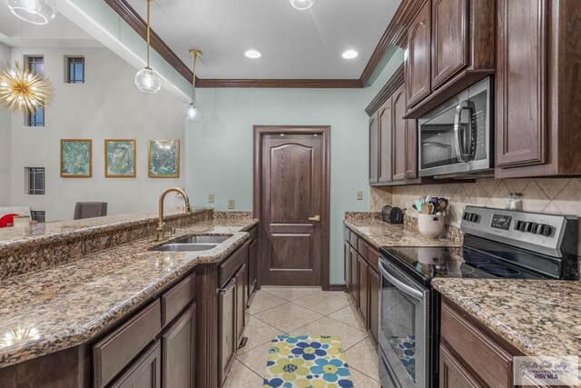 kitchen with pendant lighting, sink, stainless steel appliances, crown molding, and light stone countertops