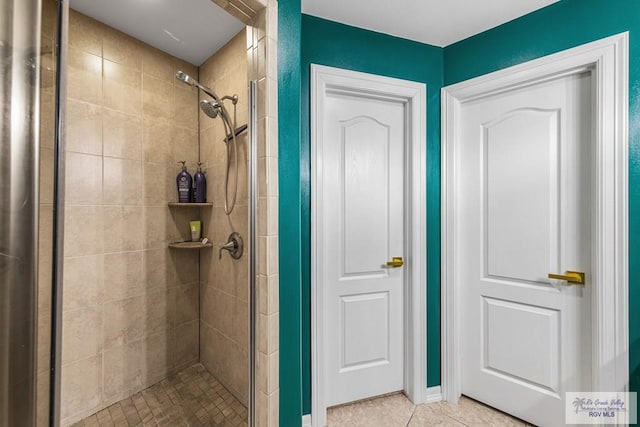 bathroom featuring tiled shower and tile patterned floors