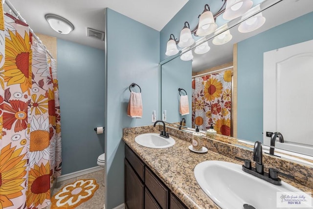 bathroom featuring tile patterned flooring, vanity, and toilet