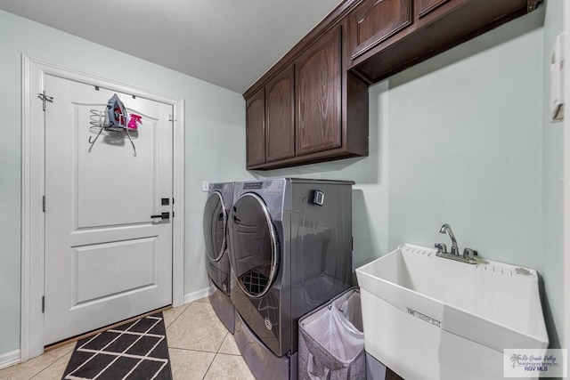 clothes washing area with cabinets, light tile patterned flooring, sink, and independent washer and dryer