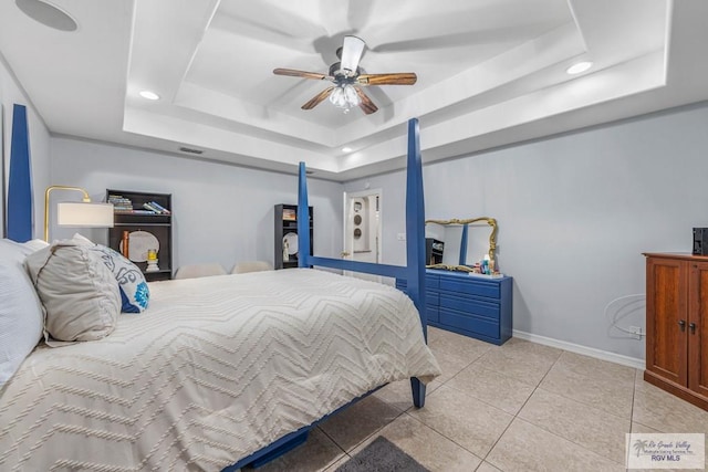 tiled bedroom featuring ceiling fan and a tray ceiling