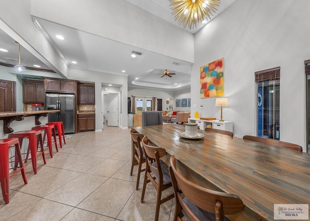 tiled dining area featuring ornamental molding and ceiling fan with notable chandelier