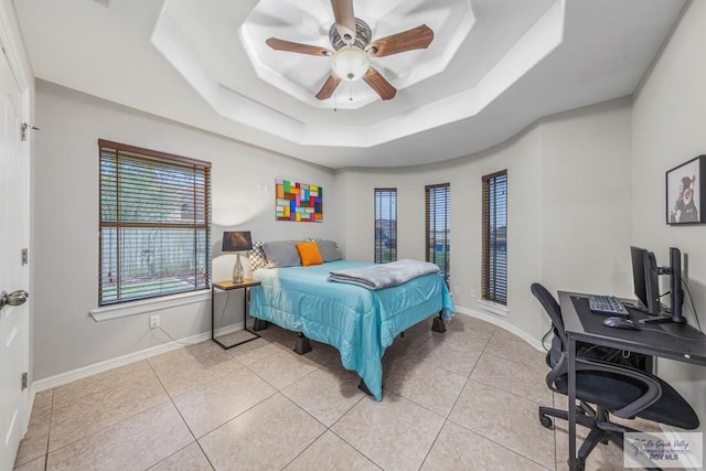 bedroom featuring light tile patterned floors, a raised ceiling, and ceiling fan