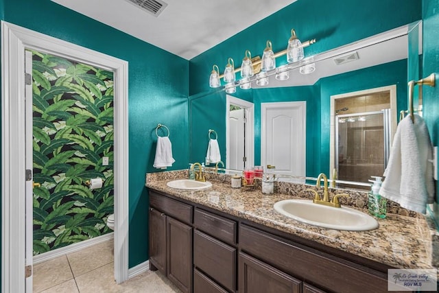 bathroom featuring tile patterned floors, vanity, toilet, and an enclosed shower