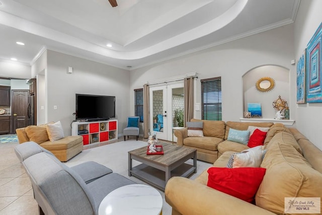 tiled living room featuring french doors, crown molding, and a raised ceiling