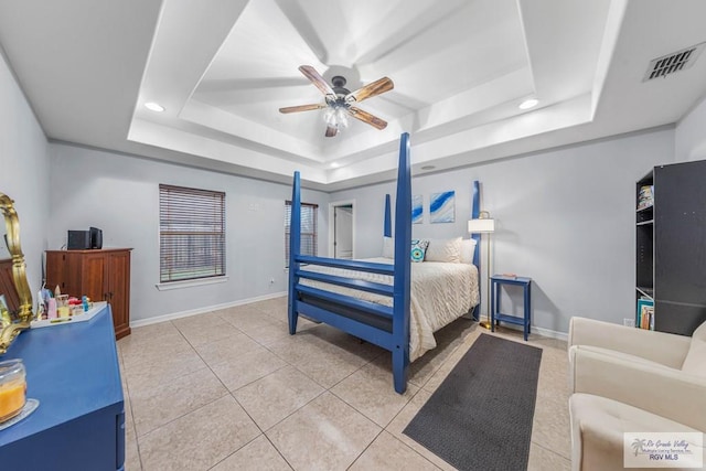 bedroom with tile patterned floors, a raised ceiling, and ceiling fan