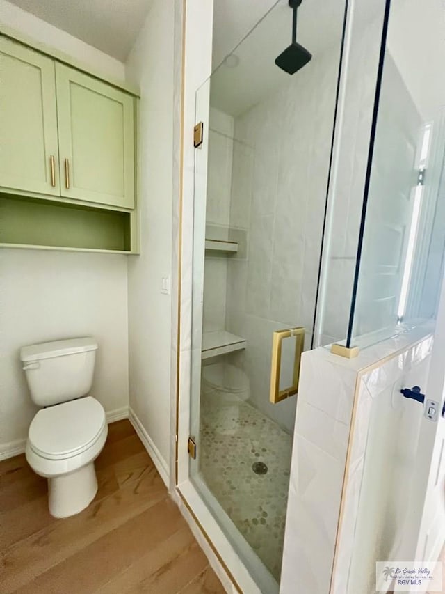 8713 Swan Lake Dr, Harlingen, TX 78552 - bathroom featuring wood finished floors, toilet, a shower stall, and baseboards