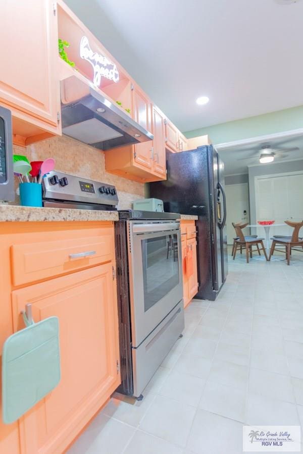 kitchen with stainless steel electric range, light tile patterned flooring, black fridge, and exhaust hood