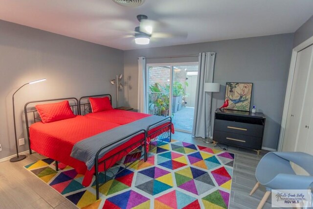 bedroom with ceiling fan, access to exterior, wood-type flooring, and a closet