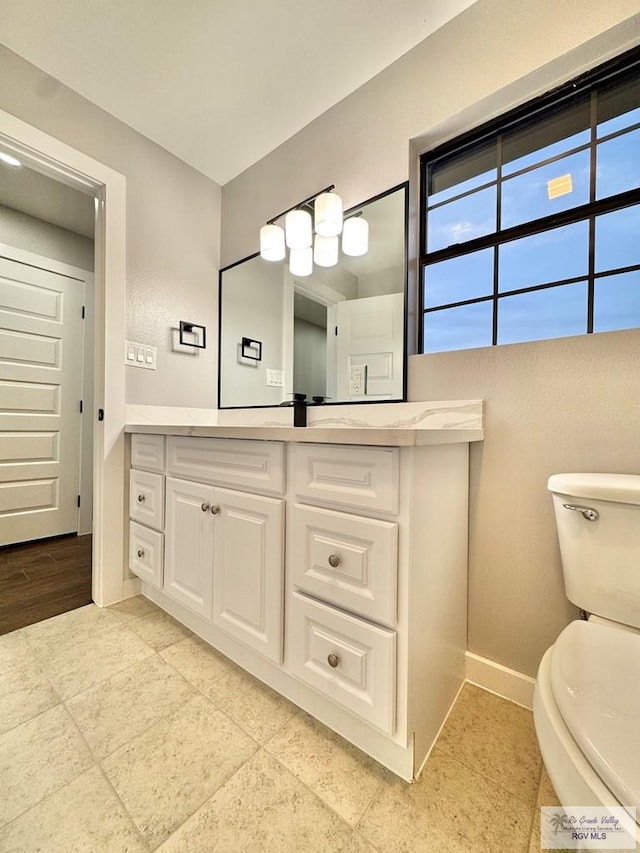 1214 W Monroe Ave, Harlingen, TX 78550 - bathroom featuring vanity, toilet, and baseboards