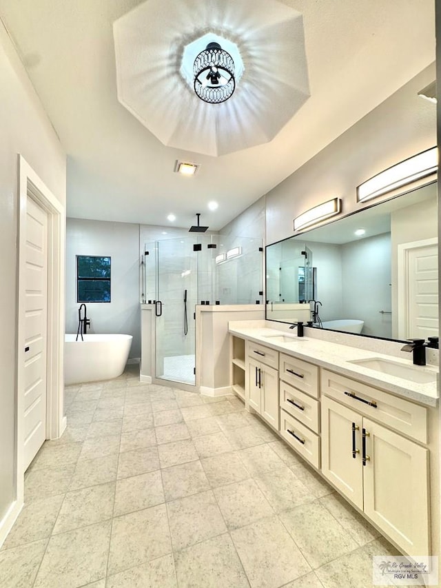 1214 W Monroe Ave, Harlingen, TX 78550 - bathroom featuring a stall shower, double vanity, a freestanding tub, tile patterned floors, and baseboards