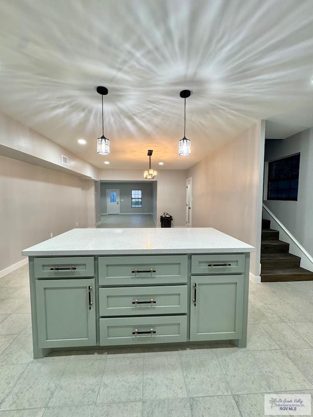 1214 W Monroe Ave, Harlingen, TX 78550 - kitchen featuring green cabinetry, baseboards, pendant lighting, and a kitchen island
