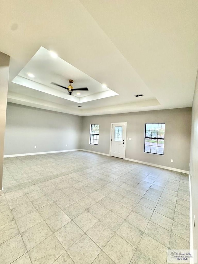 1214 W Monroe Ave, Harlingen, TX 78550 - spare room featuring a tray ceiling, baseboards, a ceiling fan, light tile patterned flooring, and recessed lighting