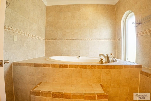 bathroom featuring tiled bath, crown molding, and tile walls