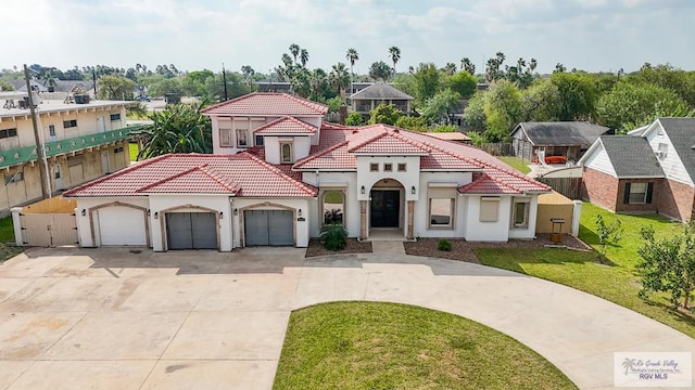 mediterranean / spanish home featuring a garage and a front yard